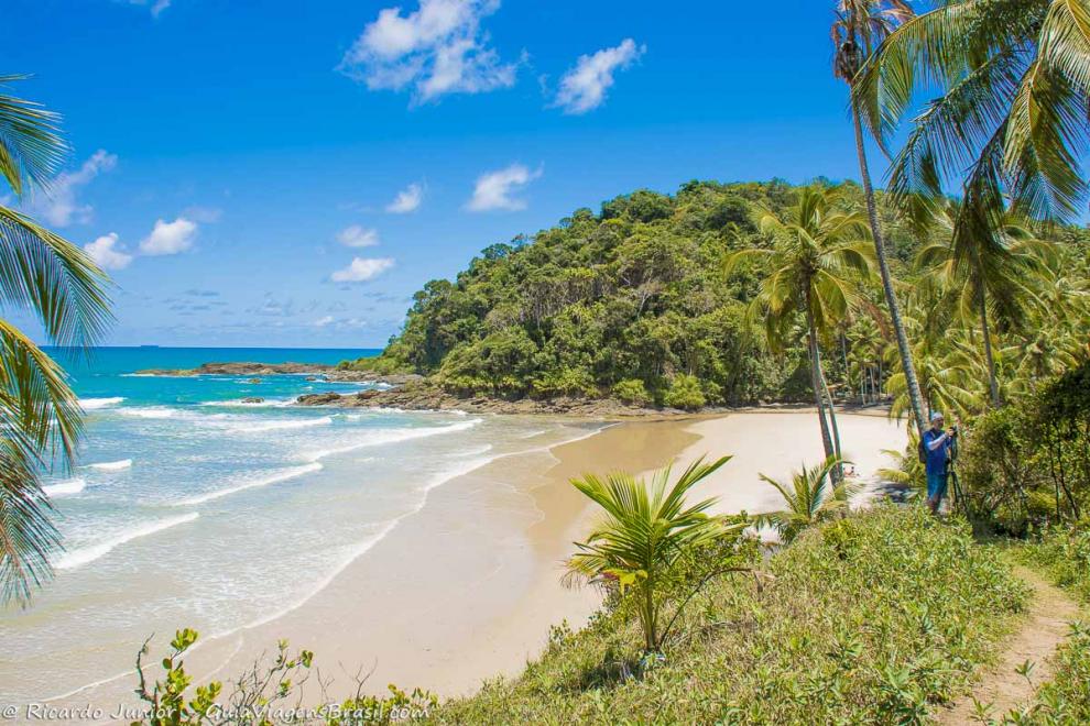 Imagem de um fotógrafo registrando as belezas da praia.